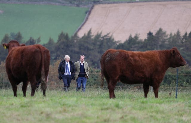 Prime Minister Boris Johnson (left) during a visit to Darnford Farm in Banchory near Aberdeen (Andrew Milligan/PA)