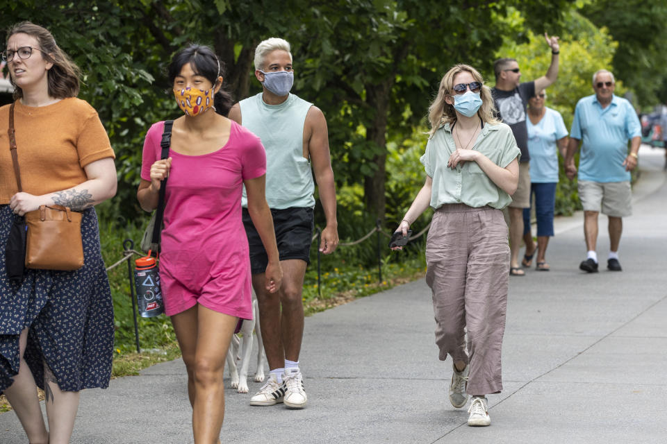 Madeline Raskay, right, and Aldany Diaz, third from left, wear face masks while walking along the Atlanta BeltLine in Atlanta's Old Fourth Ward community, Friday, May 14, 2021. Both of them say they are fully vaccinated but still prefer to wear face masks in while out in public. (Alyssa Pointer/Atlanta Journal-Constitution via AP)