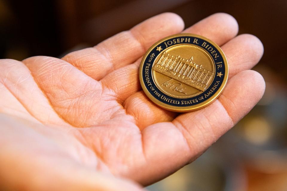 Le Roy Torres holds a challenge coin he received from President Joe Biden for Veterans Day.