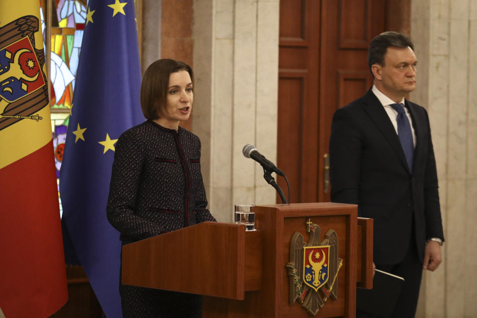 Moldovan Prime Minister designate Dorin Recean waits as President Maia Sandu, left, announces he is appointed to form a new government in Chisinau, Moldova, Friday, Feb 10, 2023. Moldova's government collapsed Friday as pro-Western Prime Minister Natalia Gavrilita resigned, adding to a series of crises that have gripped the small nation since Russia invaded its neighbor, Ukraine.(AP Photo/Aurel Obreja)