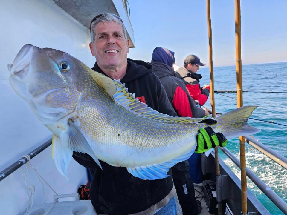 An angler on the Jamaica party boat holds a golden tilefish.