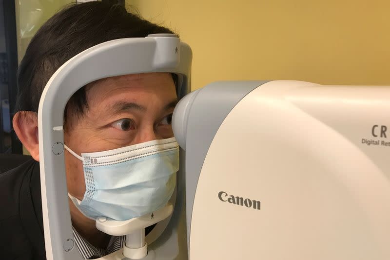 Benny Zee demonstrates retinal eye scanning technology used for early detection of autism in Hong Kong