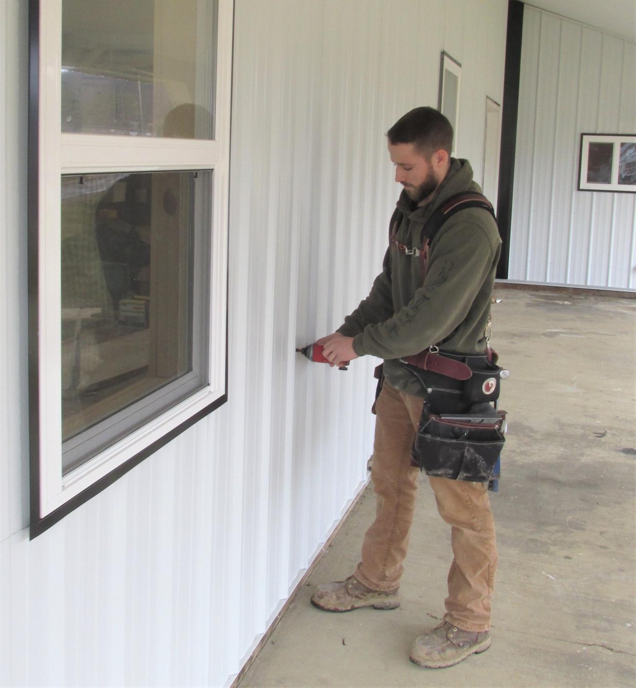 Brandon Zemrock, a 2017 graduate of the West Holmes Building Trades program, has started his own construction business. Here he works on a job site in Brinkhaven.