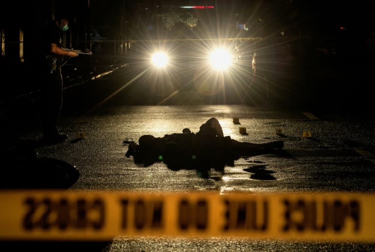 Police investigate a crime scene where two alleged drug dealers were gunned down by unidentified men in Manila