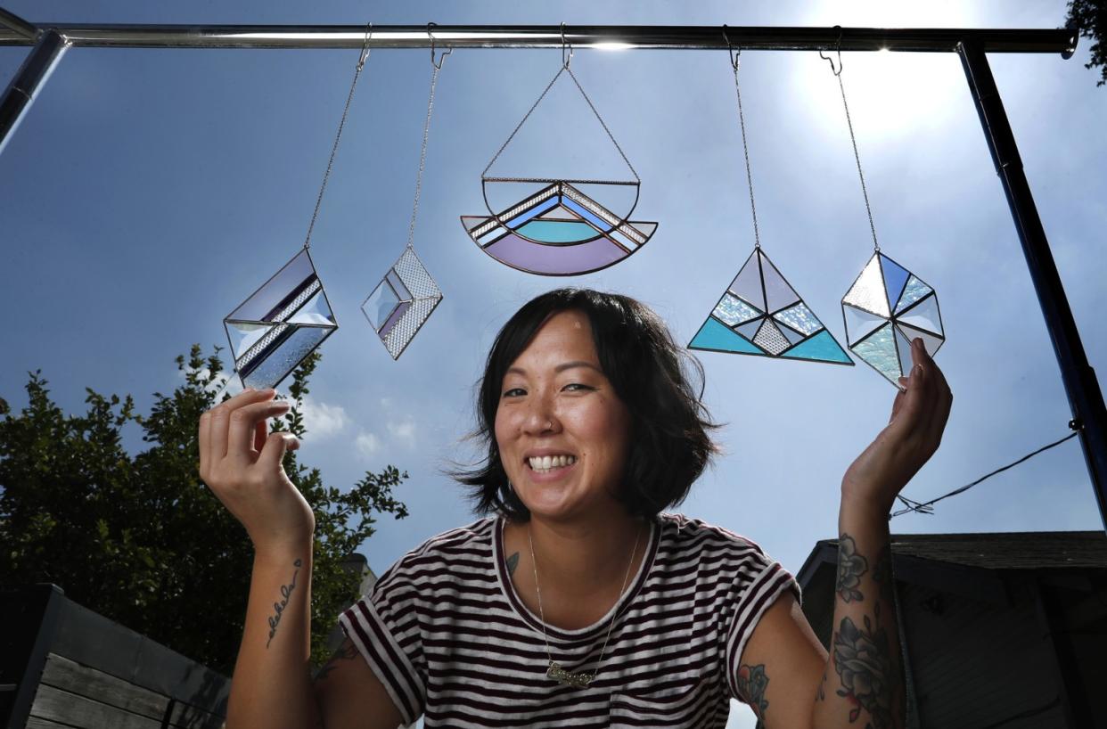 Stained-glass artist Janel Foo with some of her work.