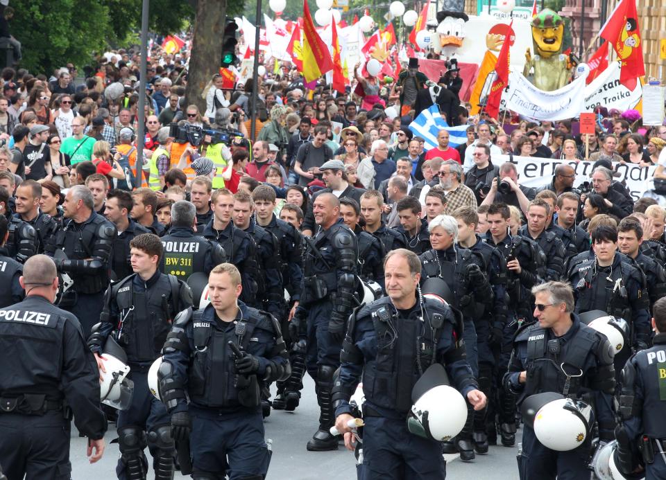 German police officers escort an anti-capitalism protest march with some 20,000 people in Frankfurt, Germany, Saturday, May 19, 2012. Protesters peacefully filled the city center of continental Europe's biggest financial hub in their protest against the dominance of banks and what they perceive to be untamed capitalism, Frankfurt police spokesman Ruediger Regis said.  The protest group calling itself Blockupy has called for blocking the access to the European Central Bank, which is located in Frankfurt's business district.  (AP Photo/Michael Probst)