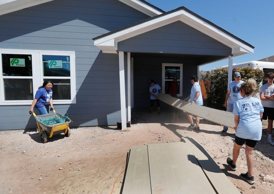 Volunteers carry building materials in before the ceremony. Lubbock Habitat for Humanity unveiled their Lubbock Capitol Build on Saturday, April 13, 2024.