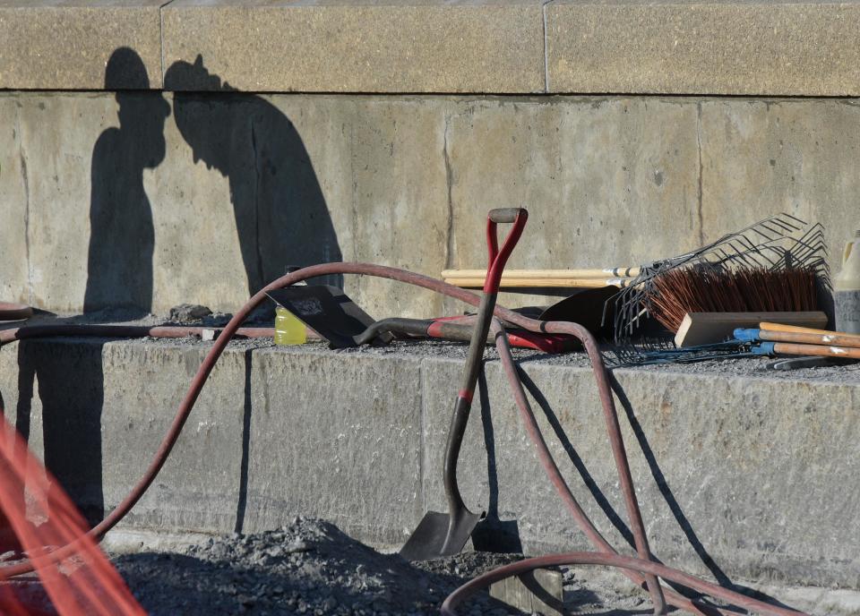 Compressor hoses, shovels and brooms fill the roadway along with piles of jackhammered pavement as crews make repairs to the aging Sagamore Bridge, now reduced to one lane in each direction snarling morning traffic.