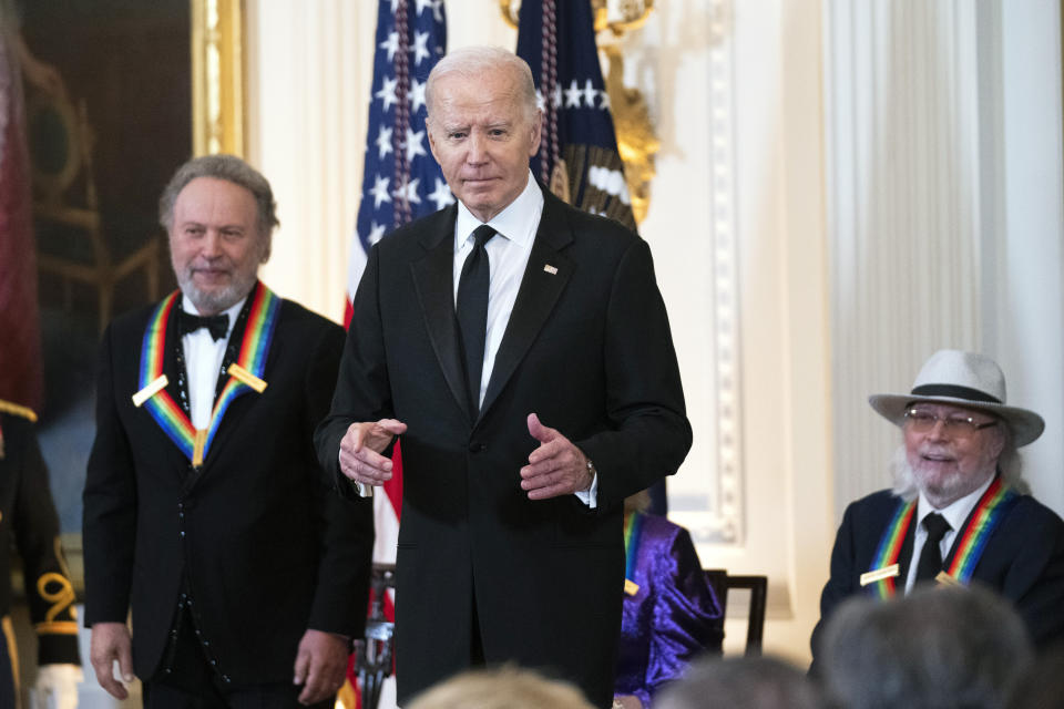 CORRECTS MONTH TO DECEMBER INSTEAD OF NOVEMBER - President Joe Biden with 2023 Kennedy Center honorees Billy Crystal, left, and Barry Gibb, right, stands on the podium in the East Room during a ceremony honoring the Kennedy Center honorees at the White House, Sunday, Dec. 3, 2023, in Washington. (AP Photo/Manuel Balce Ceneta)