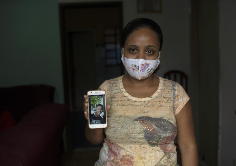 In this Monday, June 15, 2020 photo, Rafaela Matos shows a photo of her son João Pedro Matos Pinto, at her home in Sao Goncalo, Brazil. Matos' son was killed on May 18 when police burst into his aunt's house and shot the 14-year-old in the stomach with a high-caliber rifle at close range. (AP Photo/Silvia Izquierdo)