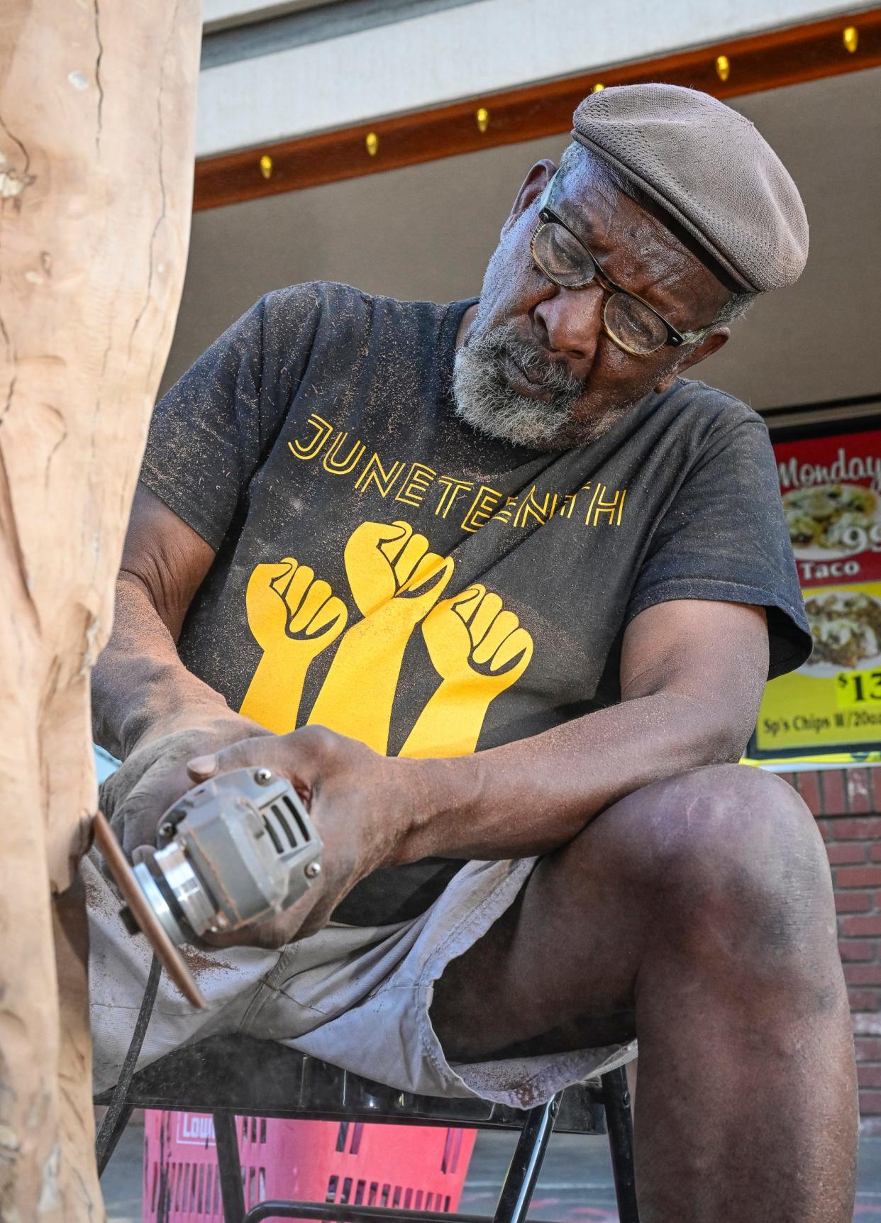 Buddy Jones carves on a tree trunk on Sept. 29 in Downtown Visalia.