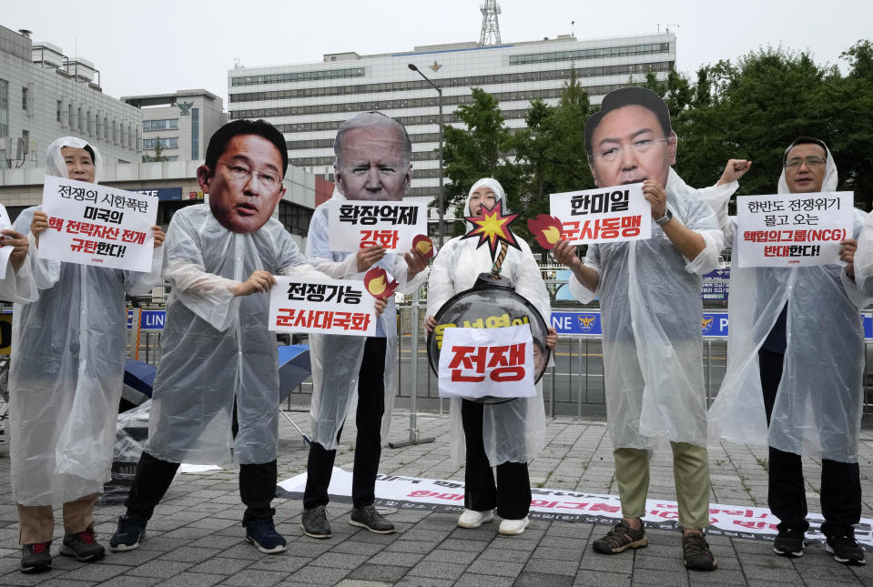 Protesters wearing masks of Japanese Prime Minister Fumio Kishida, second from left, U.S. President Joe Biden and South Korean President Yoon Suk Yeol, second from right, attend a rally against a meeting of Nuclear Consultative Group between South Korea and the United States in front of the presidential office in Seoul, South Korea, Tuesday, July 18, 2023. A bilateral consulting group of South Korean and U.S. officials met Tuesday in Seoul to discuss strengthening their nations' deterrence capabilities against North Korea's evolving nuclear threats. The signs read "Disintegration of Nuclear Consultative Group" (AP Photo/Ahn Young-joon)