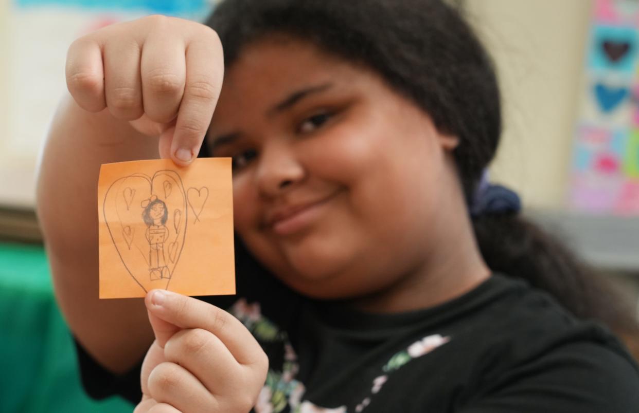 Karen Perry, 10, holds up a picture she drew of herself during th HYPE afterschool program for children whose parents are in a drug addiction recovery program.