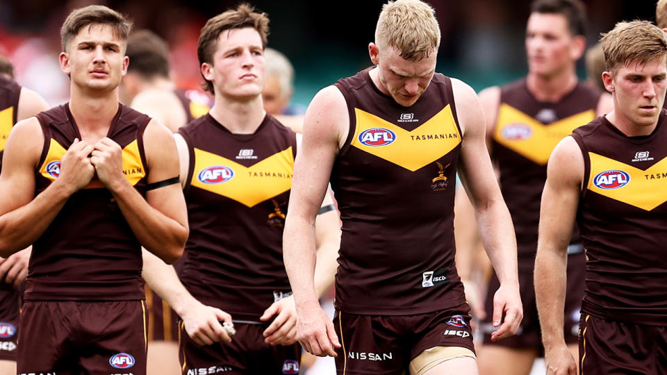 Hawthorn players look dejected as they walk off the ground after their loss to Sydney.