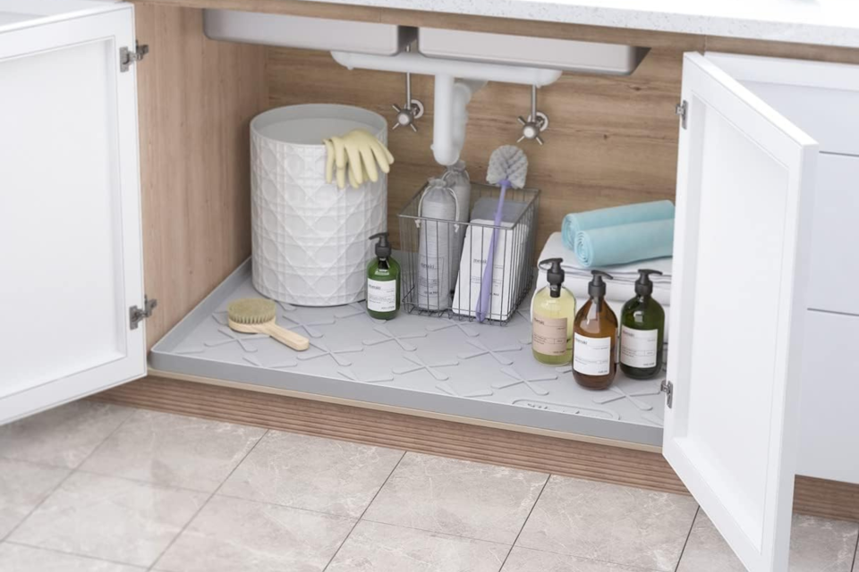 The sink mat inside a very neat-looking under-sink cabinet