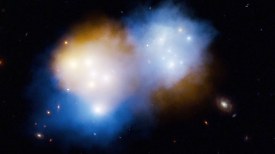     A mix of orange and blue clouds in deep space. 