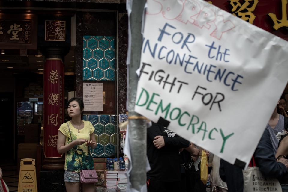 A woman looks on as she stands by a placard in an occupied area of Hong Kong on October 3, 2014. (PHILIPPE LOPEZ/AFP/Getty Images)