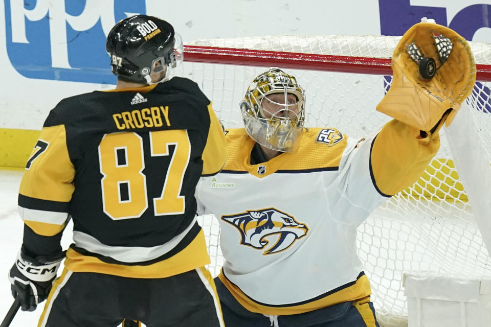 Nashville Predators goaltender Juuse Saros, right, makes a save in front of Pittsburgh Penguins' Sidney Crosby (87) during the first period of an NHL hockey game, Monday, April 15, 2024, in Pittsburgh. (AP Photo/Matt Freed)