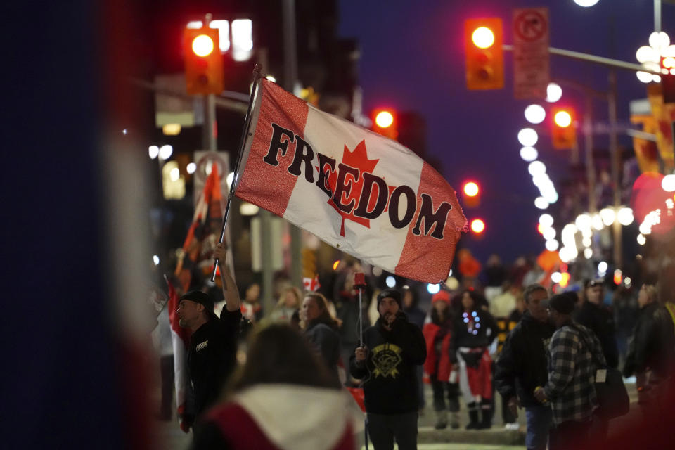 A protester waves a flag saying "freedom" during a demonstration, part of a convoy-style protest participants are calling "Rolling Thunder," in Ottawa, Ontario, Friday, April 29, 2022. (Sean Kilpatrick/The Canadian Press via AP)