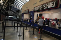 A socially limited number of fans line up at a food concession window before Game 1 of the baseball World Series between the Los Angeles Dodgers and the Tampa Bay Rays Tuesday, Oct. 20, 2020, in Arlington, Texas. (AP Photo/Sue Ogrocki)