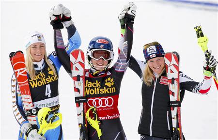 Mikaela Shiffrin of the U.S. is flanked by today's second placed Frida Hansdotter of Sweden (L) and third placed Marlies Schild of Austria following the second women's slalom run at the FIS Alpine Skiing World Cup Finals in Lenzerheide March 15, 2014. REUTERS/Leonhard Foeger