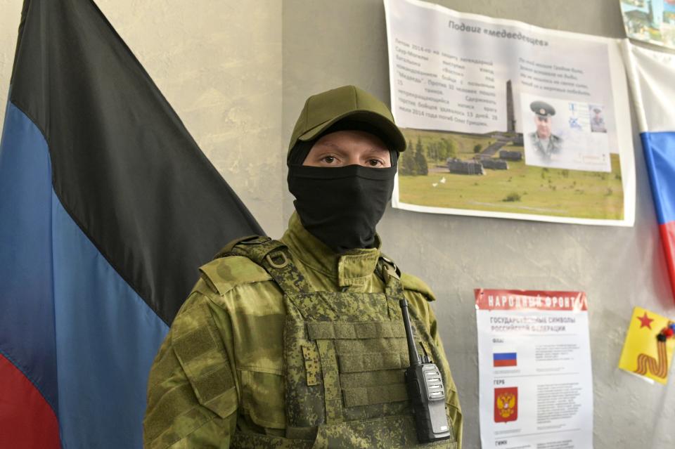 A Donetsk People's Republic serviceman stands guard at a polling station prior to a referendum in Donetsk, Donetsk People's Republic, controlled by Russia-backed separatists, eastern Ukraine, Thursday, Sept. 22, 2022. Authorities in Russian-controlled regions in eastern and southern Ukraine are preparing to hold referendums on becoming part of Russia's a move that could allow Moscow to escalate the war. The votes start Friday in the Luhansk, Kherson and partly Russian-controlled Zaporizhzhia and Donetsk regions. (AP Photo)