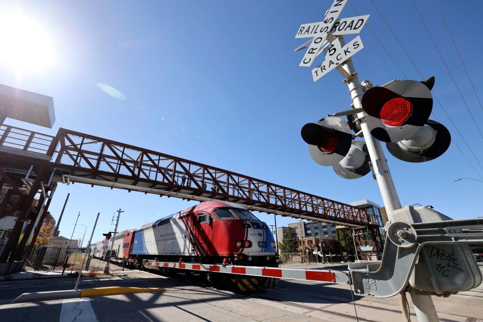 A FrontRunner train passes under a new pedestrian bridge at 300 North and 490 West, that crosses two Utah Transit Authority and three Union Pacific rail lines, in Salt Lake City on Wednesday, Oct. 18, 2023. The crossing is on a route heavily used by West High School students walking to and from school. | Kristin Murphy, Deseret News