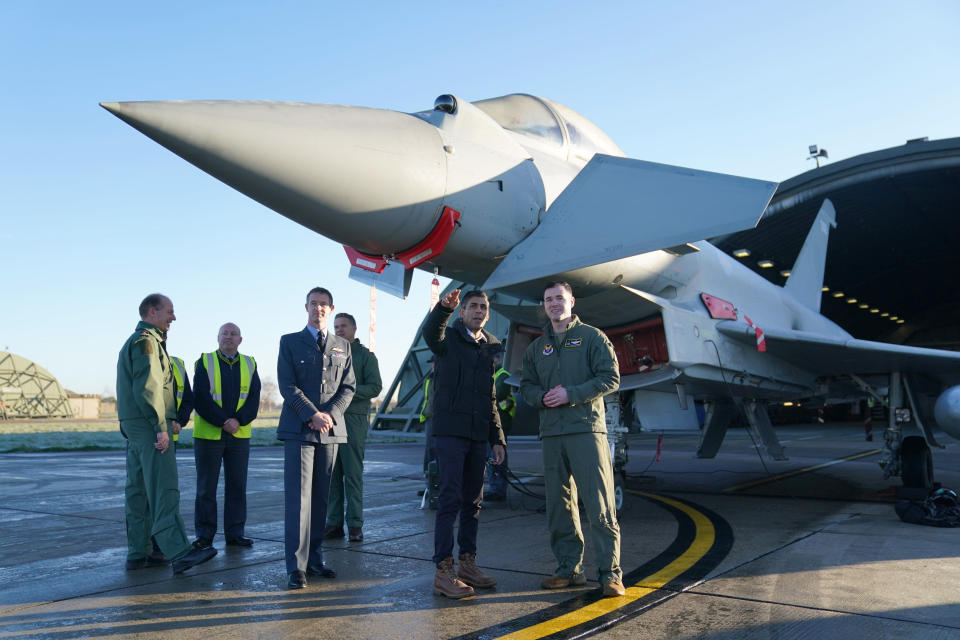 Britain's Prime Minister Rishi Sunak centre, speaks to staff during his visit to RAF Coningsby in Lincolnshire, England, Friday, Dec. 9, 2022, following the announcement that Britain will work to develop next-generation fighter jets with Italy and Japan. (Joe Giddens/Pool Photo via AP)