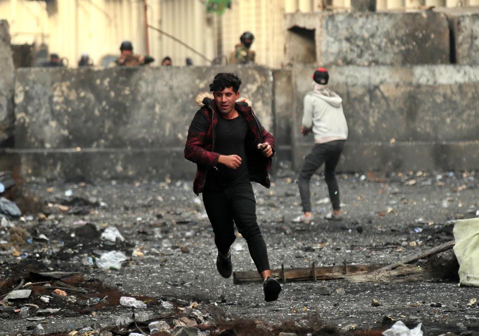 Manifestantes antigubernamentales arrojan piedras a las fuerzas de seguridad durante enfrentamientos cerca de la calle Rasheed, en Bagdad, Irak, el 6 de diciembre de 2019. (AP Foto/Hadi Mizban)