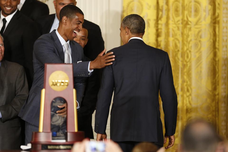 UConn men's basketball head coach Kevin Ollie (L) pats U.S. President Barack Obama (R) on the shoulder after a ceremony honoring the NCAA champion University of Connecticut Huskies men's and women's basketball teams in the East Room of the White House in Washington, June 9, 2014. REUTERS/Jim Bourg (UNITED STATES - Tags: POLITICS SPORT BASKETBALL)