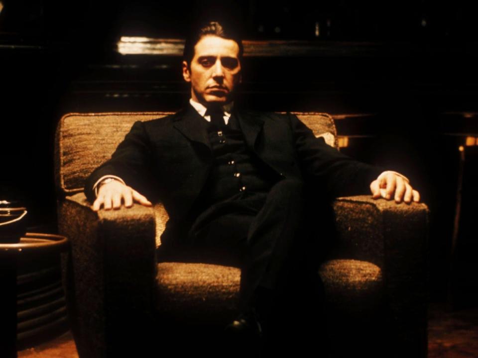 Al Pacino in a suit sitting in a chair