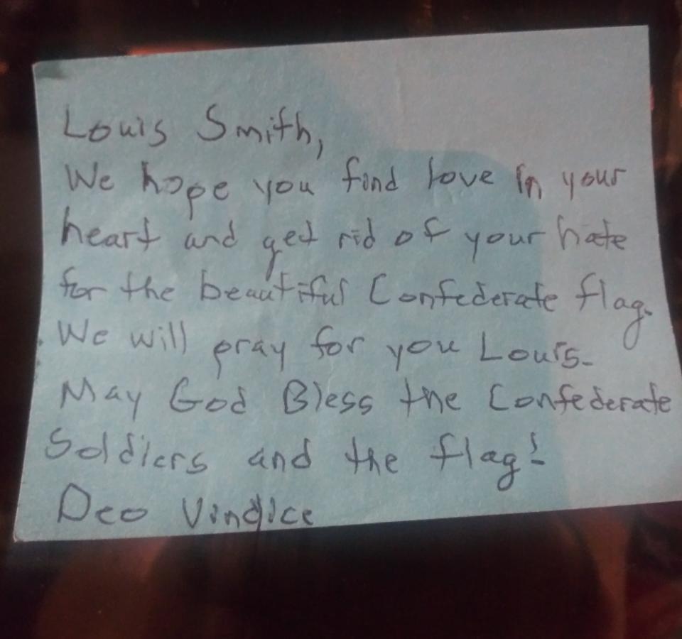 A blue sticky note addressed to Louis Smith referencing the Confederate States motto was left on the door of the Summerville Community Resource Center. (Credit: Louis Smith)