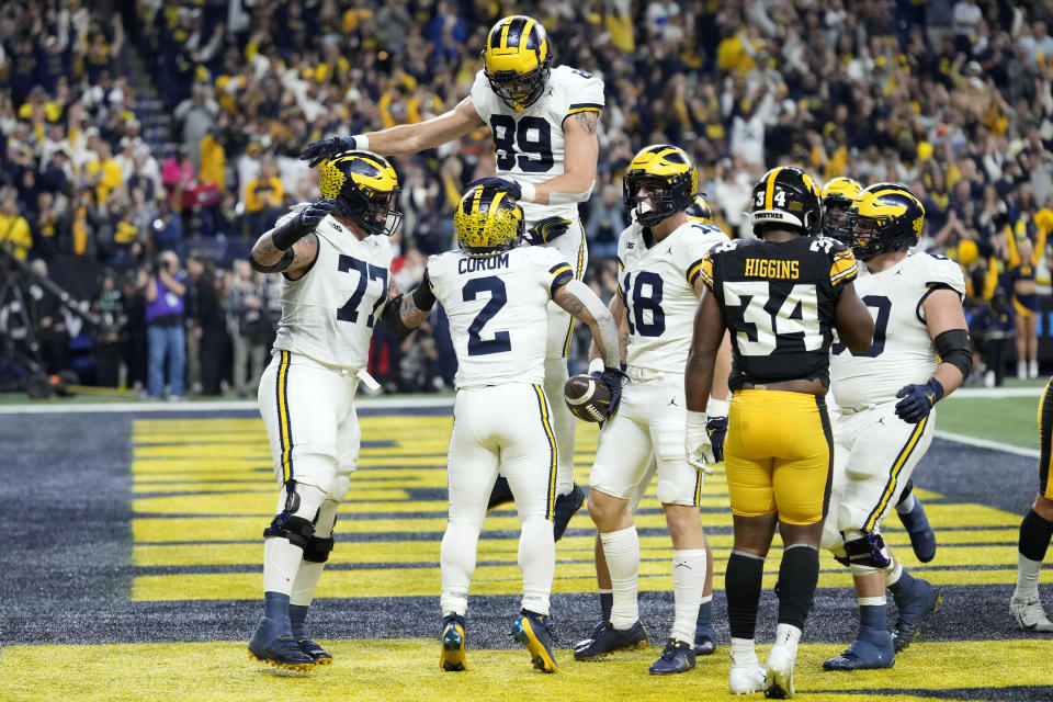 Michigan running back Blake Corum (2) celebrates with teammates after scoring on a 2-yard touchdown run during the first half of the Big Ten championship NCAA college football game against Iowa, Saturday, Dec. 2, 2023, in Indianapolis. (AP Photo/AJ Mast)