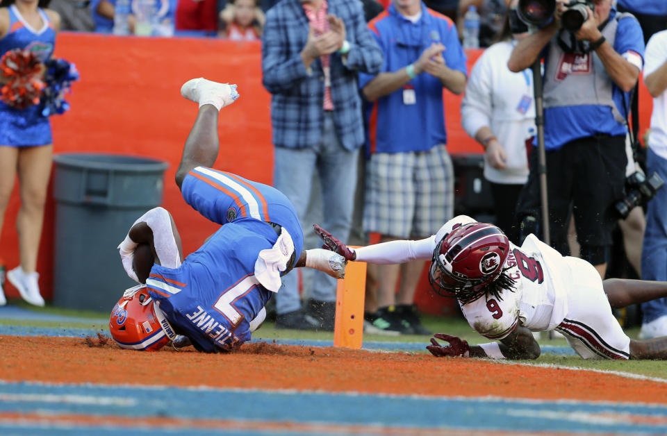 Florida running back Trevor Etienne (7) scores an 85-yard touchdown past South Carolina defensive back Cam Smith (9) during the first half of an NCAA college football game, Saturday, Nov. 12, 2022, in Gainesville, Fla. (AP Photo/Matt Stamey)