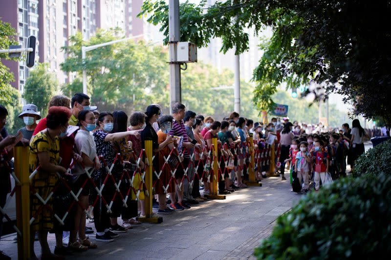 Students wearing protective face masks walk out of a primary school, following the coronavirus disease (COVID-19) outbreak in Wuhan