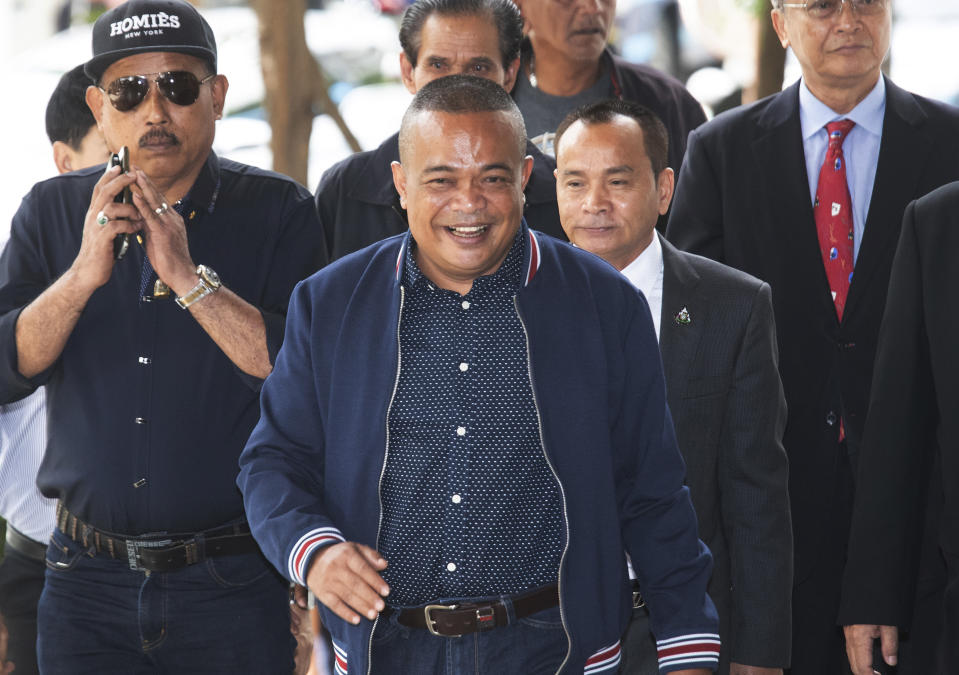 Jatuporn Phromphan, center, one of the leaders of Red Shirt, arrives at the Bangkok Criminal Court in Bangkok, Thailand, Wednesday, Aug. 14, 2019. The court has dismissed charges of terrorism and other offenses against 24 leaders of an extended street protest in 2010 that saw key parts of central Bangkok closed off and random violence that was ended by armed military force. (AP Photo/Sakchai Lalit)