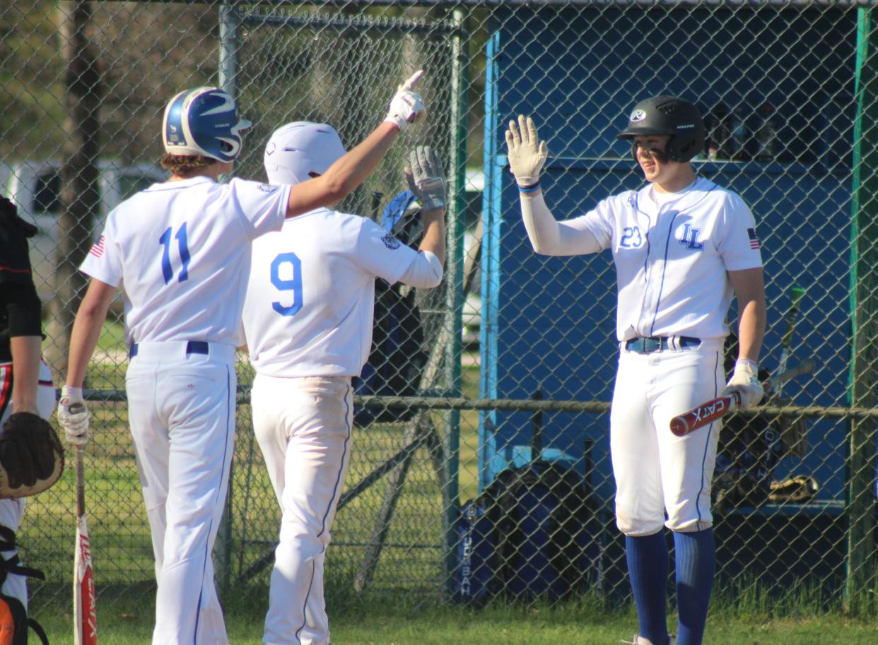 Inland Lakes’ Jake Willey (23), Connor Wallace (9) and Cash DePauw (11) celebrate after the Bulldogs scored on a three-run hit from Aidan Fenstermaker during game two of a baseball doubleheader against Mancelona on Friday.