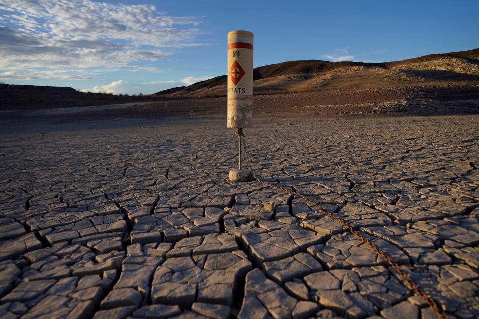 A buoy sits high and dry on cracked earth previously under the waters of Lake Mead at the Lake Mead National Recreation Area near Boulder City, Nev., on June 28, 2022. Living with less water in the U.S. Southwest is the focus for a conference starting Wednesday, Dec. 14, 2022, in Las Vegas, about the drought-stricken and overpromised Colorado River.