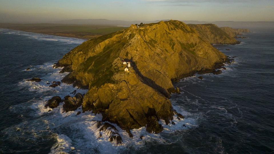 aerial view of point reyes lighthouse at sunset as it overlooks pacific ocean