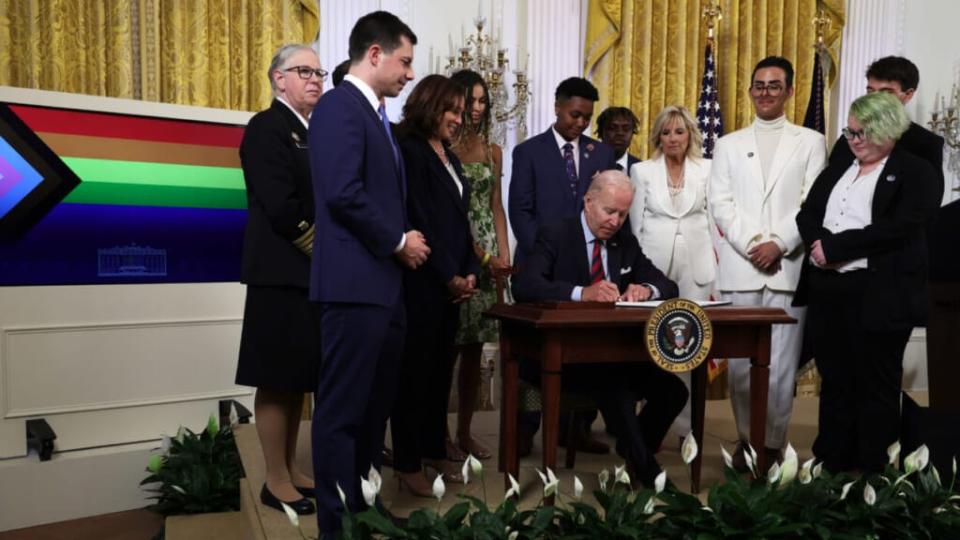 U.S. President Joe Biden signs an executive order on advancing equality for LGBTQI+ individuals as Transportation Secretary Pete Buttigieg (2nd L), Vice President Kamala Harris (3rd L), first lady Jill Biden (3rd R) and Javier Gomez (2nd R) of Florida and other LGBTQI advocates look on during a pride event at the East Room of the White House June 15, 2022 in Washington, DC. The White House held a reception to celebrate Pride Month. (Photo by Alex Wong/Getty Images)