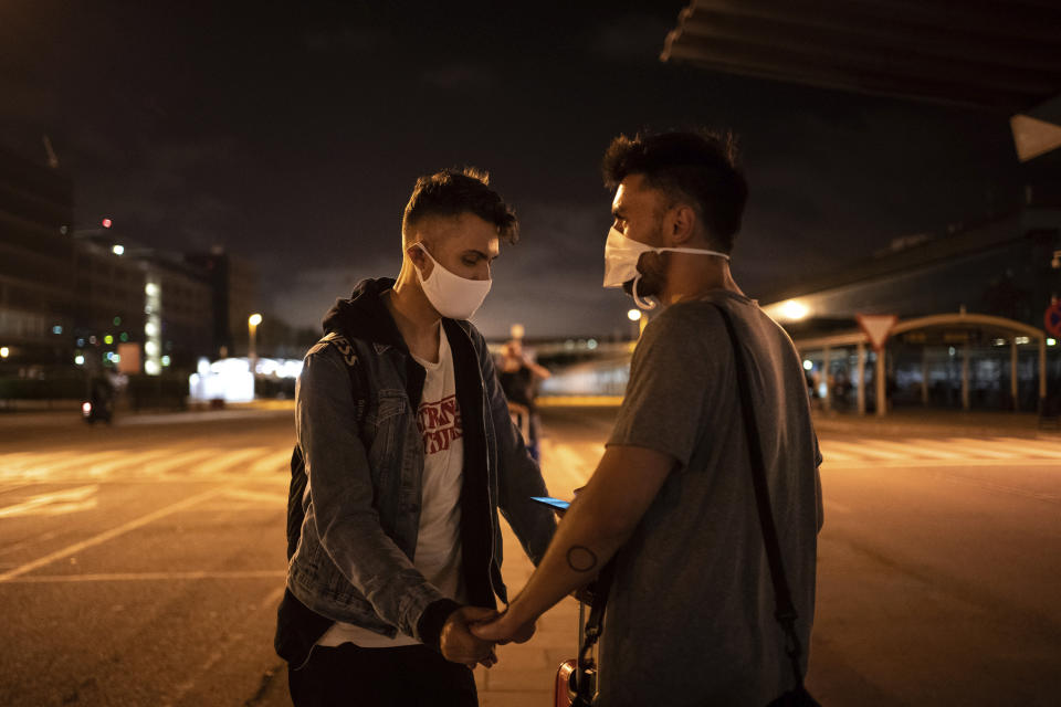 Piotr Grabarczyk y su novio, Kamil Pawlik, a la derecha, de Polonia, esperan a un taxi ante el aeropuerto tras la llegada de Grabarczyk a Barcelona, España, el miércoles 29 de julio de 2020. Como ellos, muchas personas LGTB optan por marcharse de Polonia ante la creciente homofobia fomentada por el presidente, Andrzej Duda, y otros políticos populistas conservadores en el poder. (AP Foto/Felipe Dana)