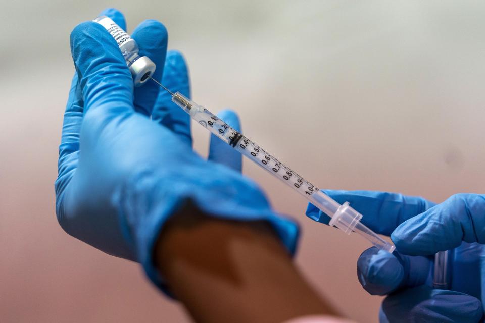 FILE — In this Jan. 31, 2021, file photo, pharmacist Diana Swiga fills a dead volume syringe with the Pfizer-BioNTech COVID-19 Vaccine, at a pop-up COVID-19 vaccination site at the Bronx River Houses Community Center, in the Bronx borough of New York. States including New York are wrestling with the decision of whether to allow medically vulnerable residents below the age of 65 to receive the coronavirus vaccine. (AP Photo/Mary Altaffer, File)