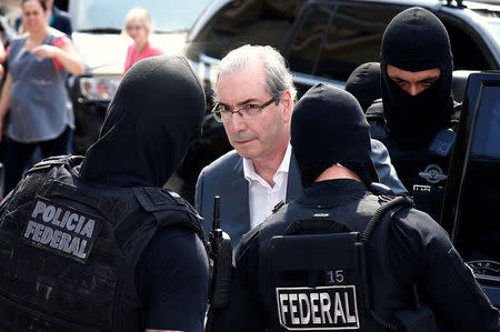 Former speaker of Brazil's Lower House of Congress, Eduardo Cunha (C), is escorted by federal police officers as he leaves the Institute of Forensic Science in Curitiba, Brazil, October 20, 2016. REUTERS/Rodolfo Buhrer