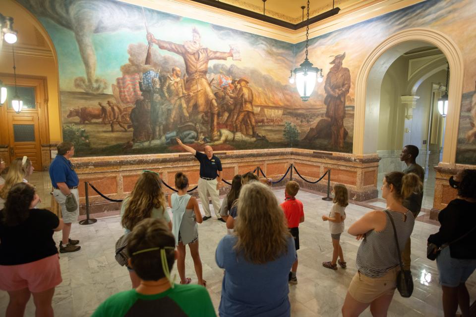 Norm Hodge, with the Kansas Historical Society, shows a tour group the famous painting "Tragic Prelude" by John Steuart Curry on Monday morning at the Kansas Statehouse in Topeka. Public tours have officially resumed at the building, although the dome is still not accessible yet.