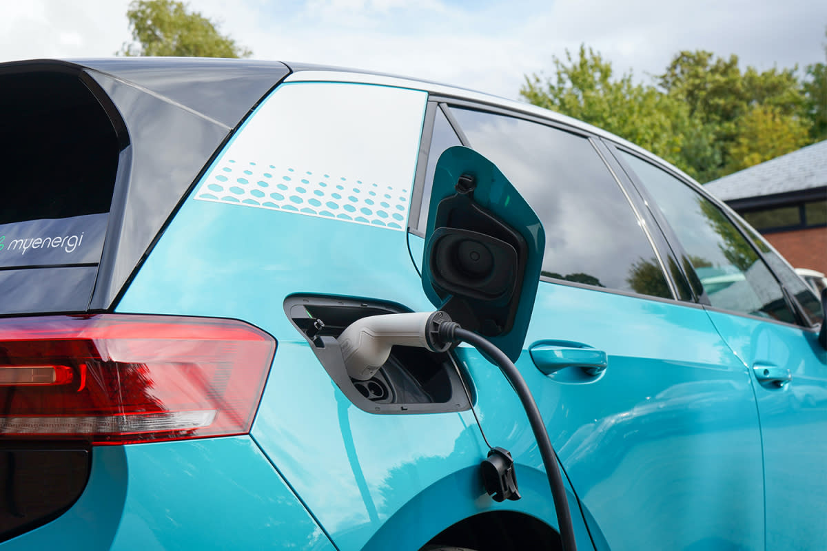 A blue electric vehicle charging at a station