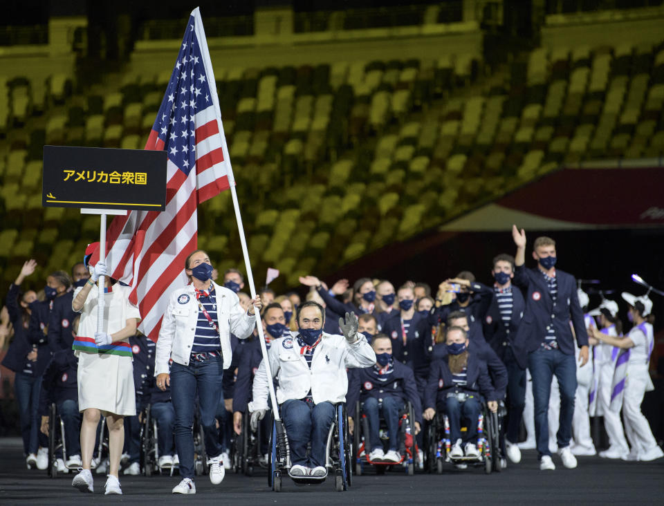 In this photo provided by the Olympic Information Service, United States Paralympic team athletes Melissa Stockwell and Charles Aoki lead the team during the athletes parade at the opening ceremonies for the Tokyo 2020 Paralympic Games in Tokyo, Japan, Tuesday, Aug. 24, 2021. (Joel Marklund for OIS via AP)