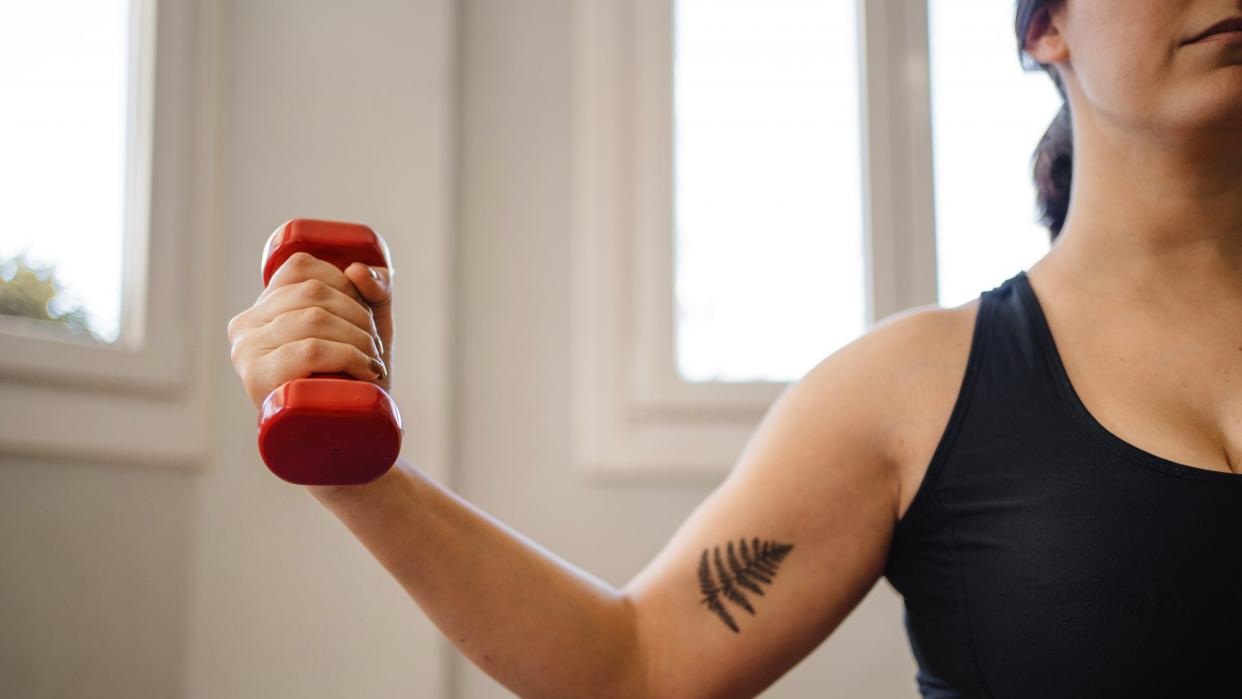 woman doing dumbbell biceps workout at home