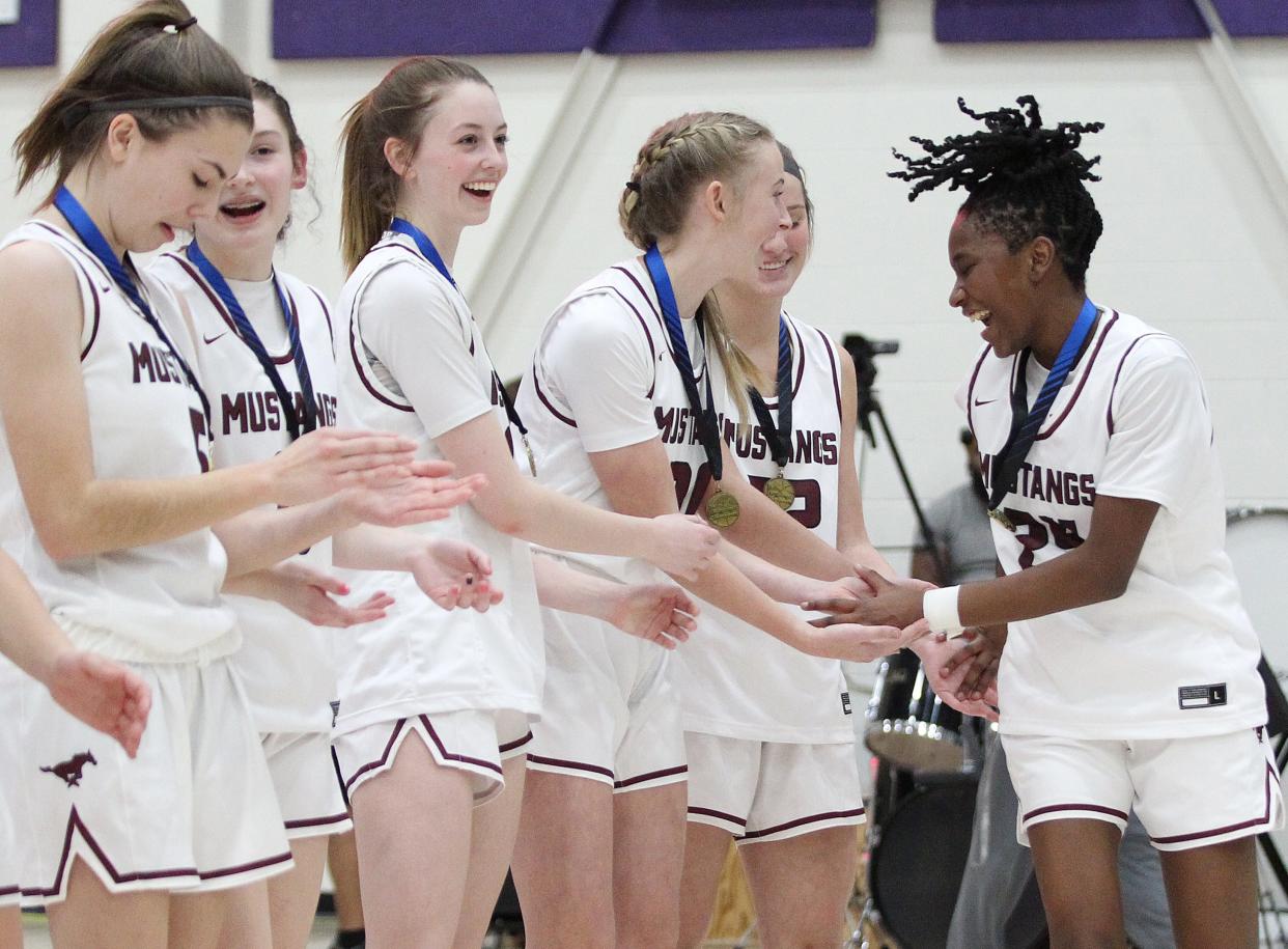 Salina Central's Mykayla Cunningham (24) celebrates with her teammates after defeating Andover 56-36 during the championship game in the Salina Invitational Tournament Saturday, Jan. 22, 2022. On Tuesday, the Mustangs became the top-ranked team in Class 5A in the latest Kansas Basketball Coaches Association rankings.