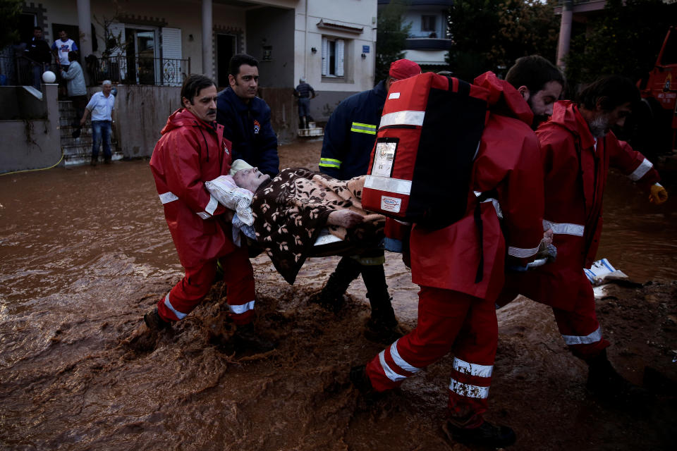 <p>Hellenic Red Cross volunteers and firemen evacuate an elderly man following heavy rainfall in the town of Mandra, Greece, Nov. 16, 2017. (Photo: Alkis Konstantinidis/Reuters) </p>