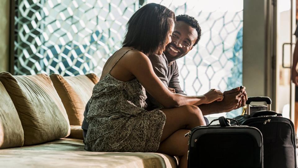 couple smiling at each other sitting on couch